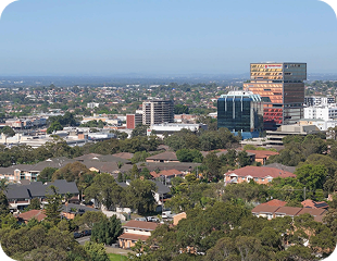 Aerial view of suburban Sydney with residential areas and modern buildings, representing service locations for Ability to Achieve's disability care in Western and South Sydney.