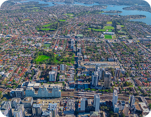 Aerial view of suburban Sydney, showcasing residential areas, green parks, and urban infrastructure, relevant to Ability to Achieve's disability services across Western and South Sydney.