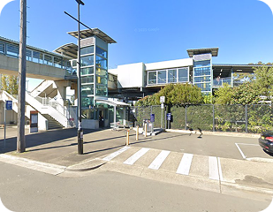 Modern transport hub in Sydney, featuring accessible entry, greenery, and nearby parking, relevant to Ability to Achieve's service areas.