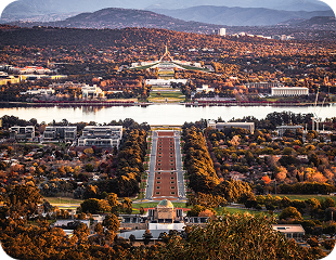 Panoramic view of Canberra featuring the Australian Parliament House, Lake Burley Griffin, and surrounding landscapes, highlighting the city’s natural beauty and urban design.