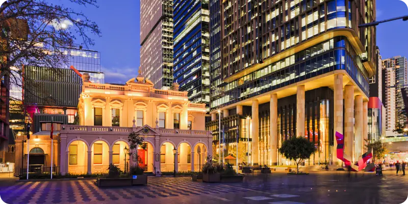 Historic building and modern skyscrapers in Parramatta, showcasing the blend of community heritage and contemporary development, reflecting Ability to Achieve's commitment to supporting local disability services.