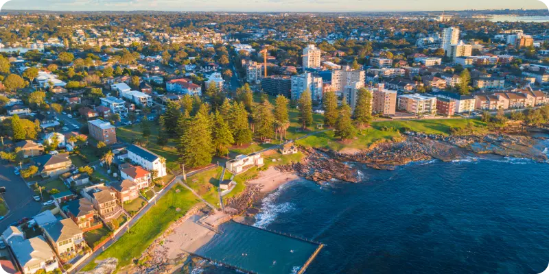Aerial view of Cronulla, showcasing coastal lifestyle, residential areas, and community spaces near the beach, highlighting the relaxed atmosphere and accessibility for disability support services.