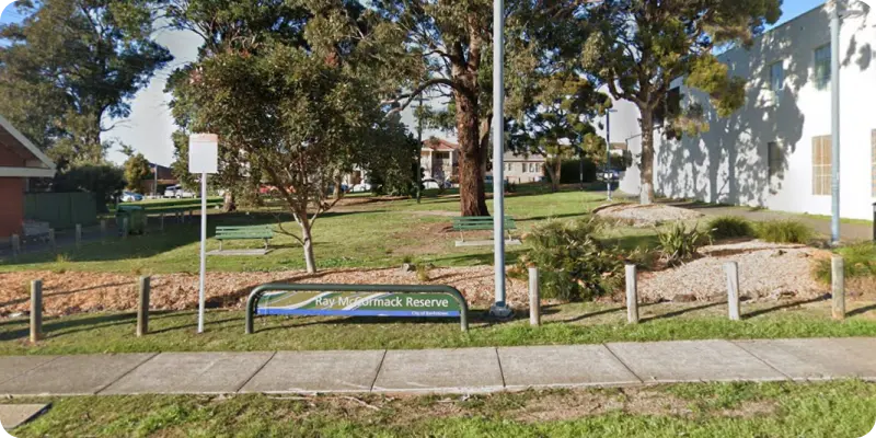 Ray McCormack Reserve in Revesby featuring green spaces, benches, and trees, highlighting the community atmosphere for disability support services.