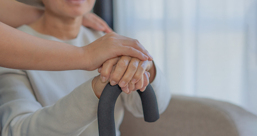 Hands of a support worker assisting a participant with a mobility aid, symbolising personal care and support for independent living under NDIS.